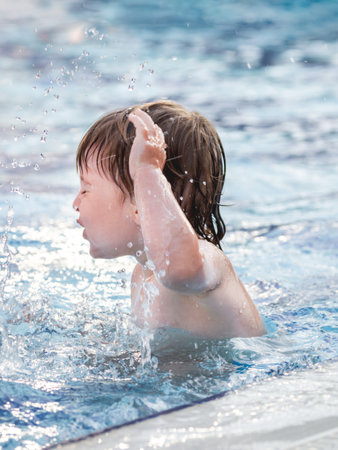 Toddler floats in paddling pool. Teaching children to swim from early childhood. Sport, active lifestyle and physical development.の写真素材