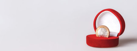 Red gift box with one euro coin, official currency of the eurozone. European Union currency...