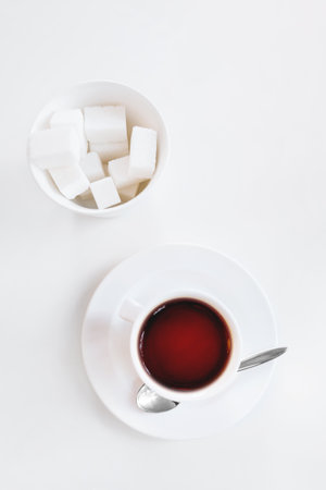Top view on cup of coffee and glass vase with sugar on white background. coffee break.の写真素材
