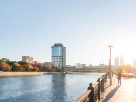 MOSCOW, RUSSIA - October 16, 2022. Panorama view of Bagration bridge and Tower 2000 of Moscow International Business Center. People walks on Krasnopresnenskaya embankment at autumn sunset.のeditorial素材