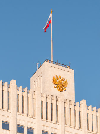 MOSCOW, RUSSIA - October 16, 2022. Top tower of White House, House of Government of Russian Federation. Famous building with state emblem and national flag at autumn sunset.のeditorial素材