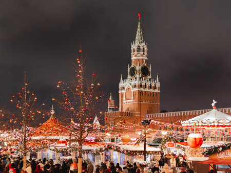 MOSCOW, RUSSIA - December 19, 2021. Spasskaya tower of Kremlin over light bulbs of traditional Christmas fair on Red square. People celebrate New Year.のeditorial素材