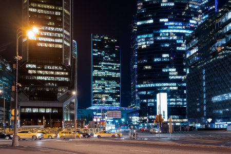 MOSCOW, RUSSIA - November 11, 2022. Yandex Taxi is moving fast on urban road among skyscrapers. Illuminated towers Moscow International Business Center.のeditorial素材