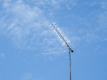 TV rooftop antenna on blue sky background. Industrial equipment used to receive internet signal, television connection and communication.の写真素材