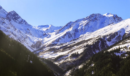 Snow landscape of the morning sunlight falling on the huge snowy mountain of Kheerganga, India in...