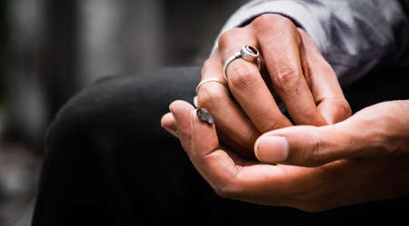 Close up of a Hand Holding Malana Cream Hashish on the tip of the forefinger in the crushing process, a red ruby ring is on the other hand, 5Kの写真素材