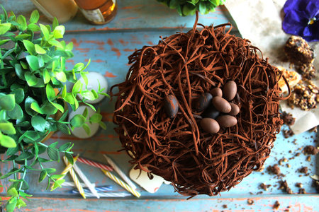 Chocolate cake with chocolate eggs on top, with green plants in the background in bakeryの写真素材