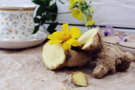 A cup of tea on a table with ginger and ground turmeric. Concept of health.