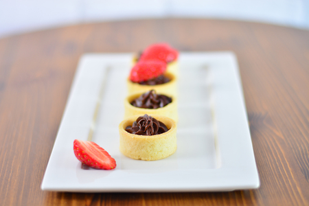 Fresh and delicious small chocolate cakes on wooden tableの写真素材