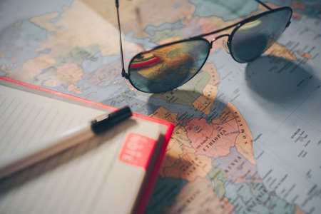 The adventure with the map and the camera, note on a wooden table. Travel and vintage concepts.の写真素材