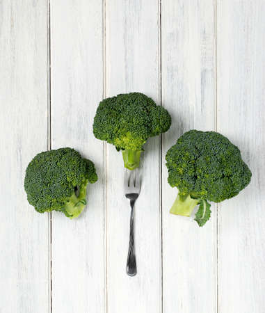 Fresh broccoli on a wooden table with fork. Artistic nutrition concept.の写真素材