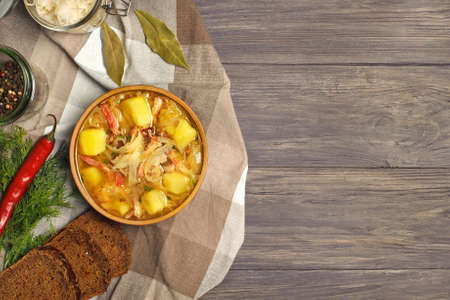 Sauerkraut soup in bowl with black pepper and bay leaves on the side. Photographed overhead on rustic wood.Copy space.
の写真素材