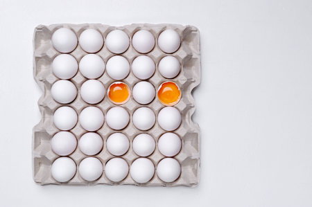 Eggs in paper tray with cracks open. The egg diet concept.