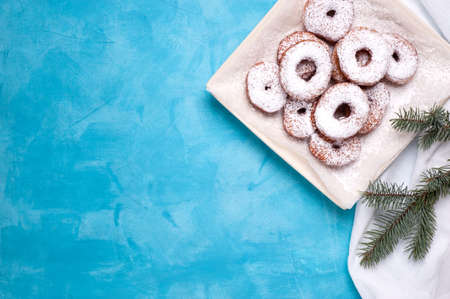 Sweet donuts on a plate, located on a white linen napkin. Decorated with a branch of a fir tree.Image with space for text.Horizontal orientation.の写真素材