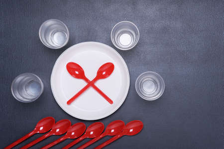 Disposable tableware plates and spoons. Plastic contaminates the earth and water. Concept of  environmental pollution. Top view.の写真素材