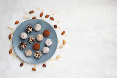 Healthy organic energy bites with nuts, chia seeds, almonds, coconut  and dried fruits, vegan raw dessert snacks on a table. Flat lay, horizontal orientation.の写真素材