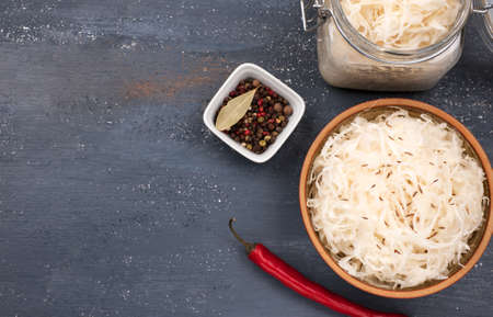Fermented cabbage. Vegan food. Sauerkraut with  spices. In bow and jarl on the dark background. Trend food concept.の写真素材