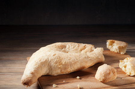 Georgian bread lavash with torn pieces on the wooden background.Delicious traditional homemade bread...