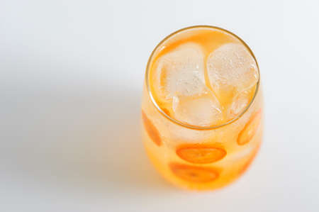Fresh Kumquat lemonade with ice cubes on white background. Cold detox  drink. Copy space for textの写真素材