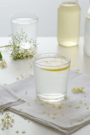 Lemonade from elderflowers with  lemon on the table. Delicious and refreshing homemade cold drink .Vertical orientation.の写真素材