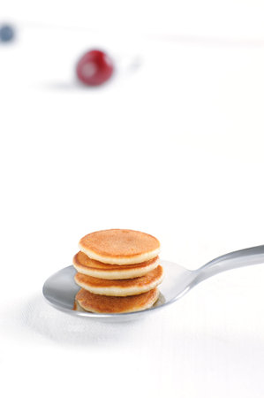 Homemade tiny cereal pancakes on the spoon.  Trendy breakfast. Vertical orientation.の写真素材