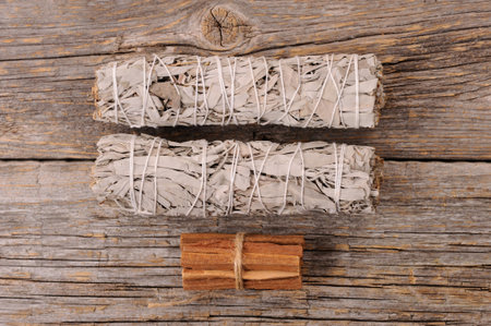 Dried white sage smudge bundles and palo santo sticks  on old  wooden background. Energy clearing...