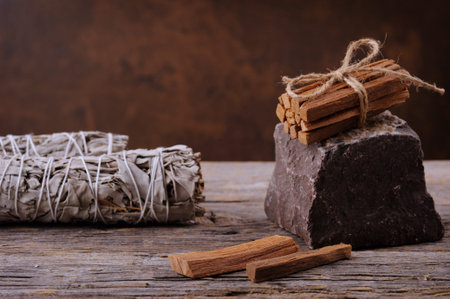 White sage smudge sticks and palo santo smudging sticks on the old wooden background.
