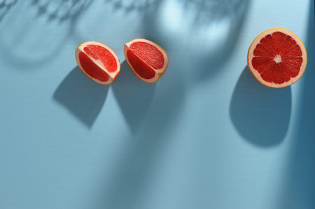 Creative  background  with slices of grapefruit  and shadows in minimal style. Creative summer layout. Horizontal orientation with space for text.の写真素材