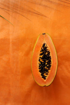 Creative background with Papaya  and  leaf on the background.  Food background. Vertical orientation with space for text.の写真素材