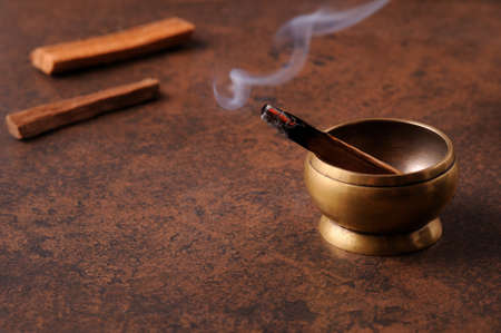 Aromatic stick of palo santo  on dark background. Holy sacred tree stick, burning with aroma smoke.Smoking herbal incense.  Healing, meditation, relaxation concept.の写真素材