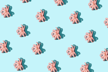 Creative pattern made with pink baby octopuses against vibrantÂ  blue background. Minimal seafood summer concept. Isometric view.の写真素材