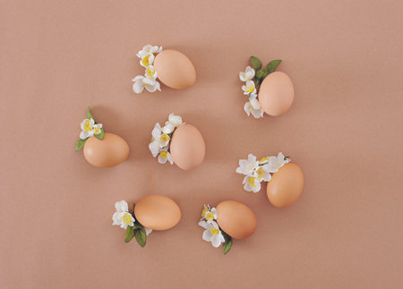 2021 Easter composition. Eggs with white flowers and leaves. Flat lay minimal background.の写真素材