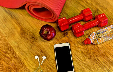 Dumbbells, water bottle, smartphone, headphones and apple. Fitness conceptの写真素材