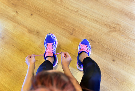 Young girl is tying her shoes for running