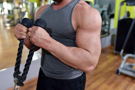 Muscular guy is training at the fitness center