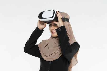 Woman show emotion reaction gesturing while using virtual reality headset against white backgroundの写真素材