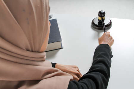 Beautiful Muslim woman Judge wear Hijab striking the gavel on a desk. Justice and Law Conceptの写真素材