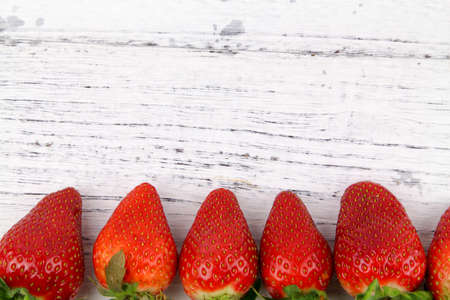 Close up row of Fresh healthy fruits Strawberries with leaves over wooden texture background. Copy Space concept. Healthy Foodの写真素材