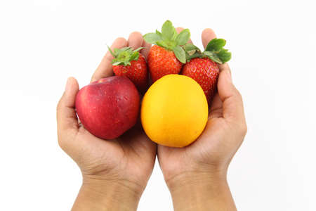 Hand holding Fresh healthy fruits Strawberries, orange and apple isolated on white background. Copy Space concept. Healthy Foodの写真素材