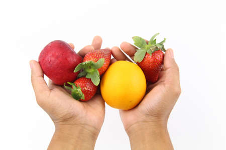Hand holding Fresh healthy fruits Strawberries, orange and apple isolated on white background. Copy Space concept. Healthy Foodの写真素材