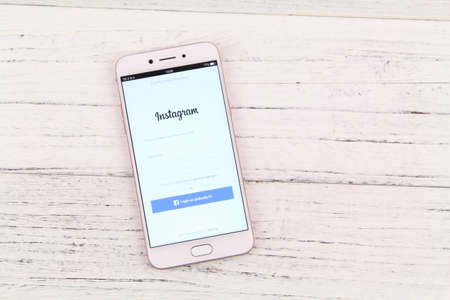 KUALA LUMPUR, MALAYSIA - 6th August 2017: A smart phone with Instagram application on the screen over wooden texture background.  Instagram is a photo-sharing app for smartphonesのeditorial素材