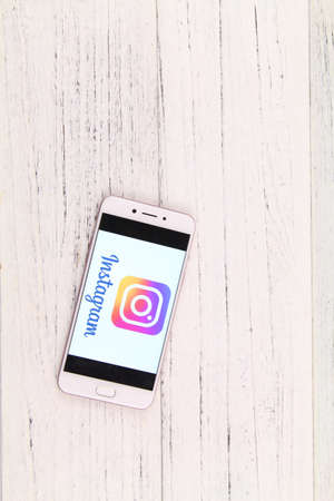 KUALA LUMPUR, MALAYSIA - 6th August 2017: A smart phone with Instagram application on the screen over wooden texture background.  Instagram is a photo-sharing app for smartphonesのeditorial素材