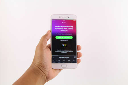 KUALA LUMPUR, MALAYSIA - 6th August 2017: A smart phone with Spotify application on the screen over wooden texture background. Spotify is a music, podcast, and video streaming service.のeditorial素材