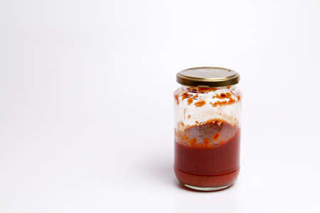 Open Glass jar with delicious homemade classic spicy tomato pasta or pizza sauce isolated white backgroundの写真素材