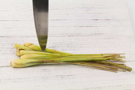 Fresh lemongrass with a sharp knife over wooden backgroundの写真素材