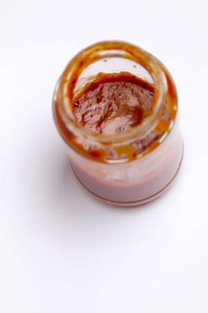 Open Glass jar with delicious homemade classic spicy tomato pasta or pizza sauce isolated white backgroundの写真素材