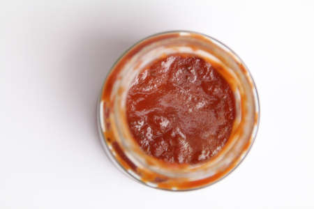 Open Glass jar with delicious homemade classic spicy tomato pasta or pizza sauce isolated white backgroundの写真素材