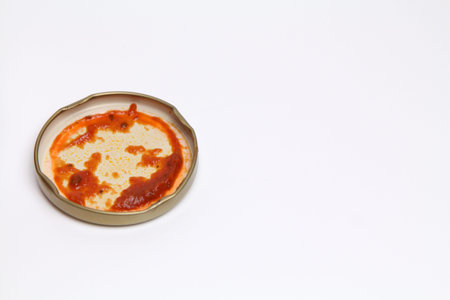 Open Glass jar with delicious homemade classic spicy tomato pasta or pizza sauce isolated white...