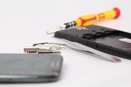 Cell phone repair. Smartphone parts and tools for recovery, selective focus.