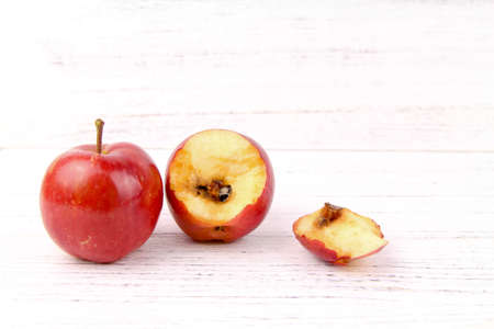 A good and bitten red apple rotten from inside isolated white backgroundの写真素材
